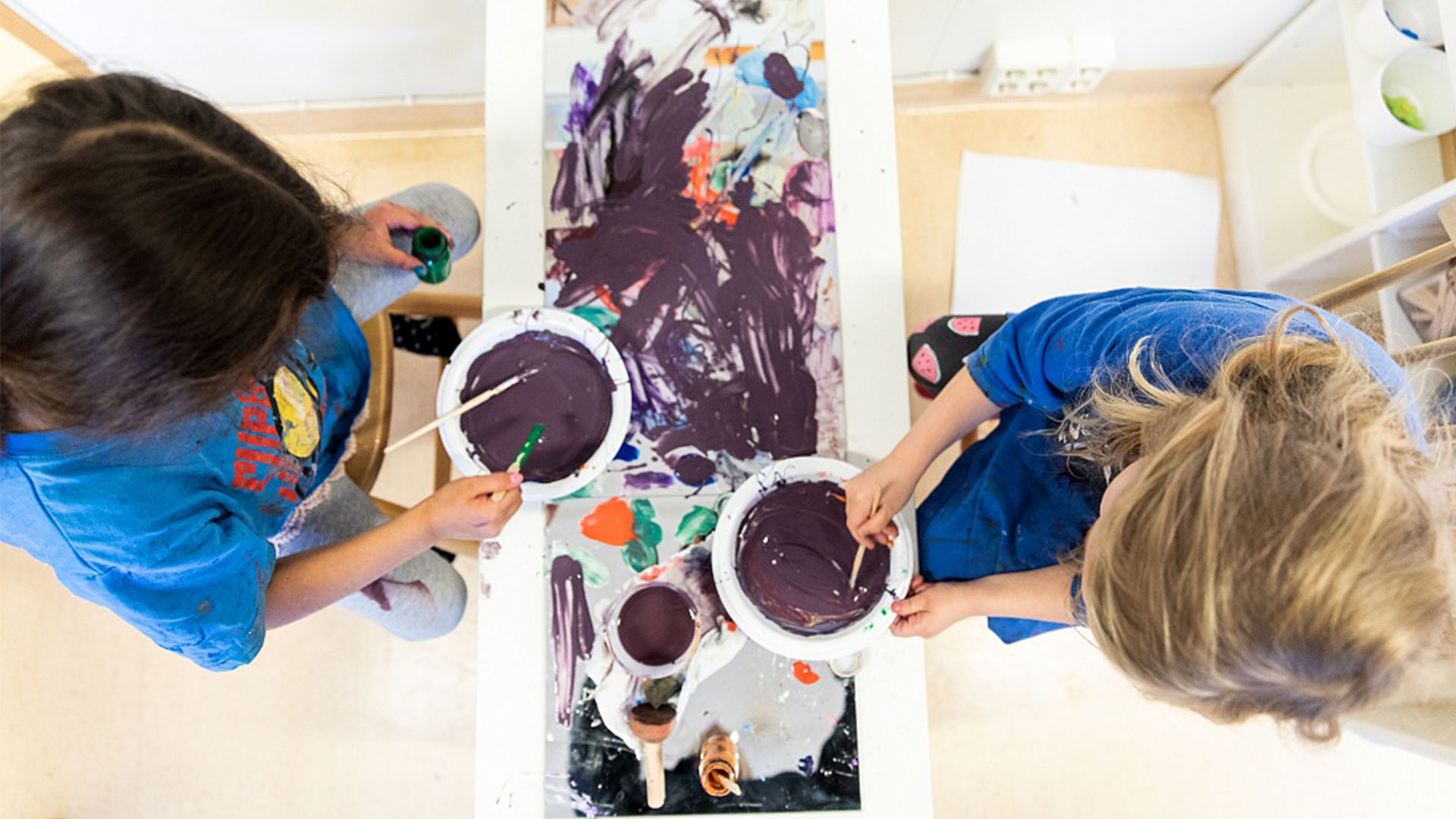 Två barn blandar målarfärg