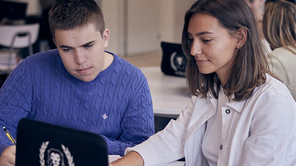 Två elever på Sjölins gymnasieskola sitter i ett klassrum och tittar på en datorskärm