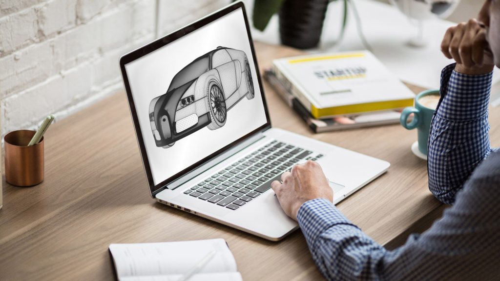 En person sitter och designar en 3D-modell av en bil genom CAD