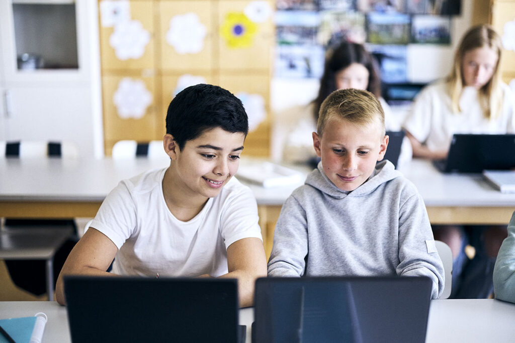 Elever framför en dator i ett klassrum